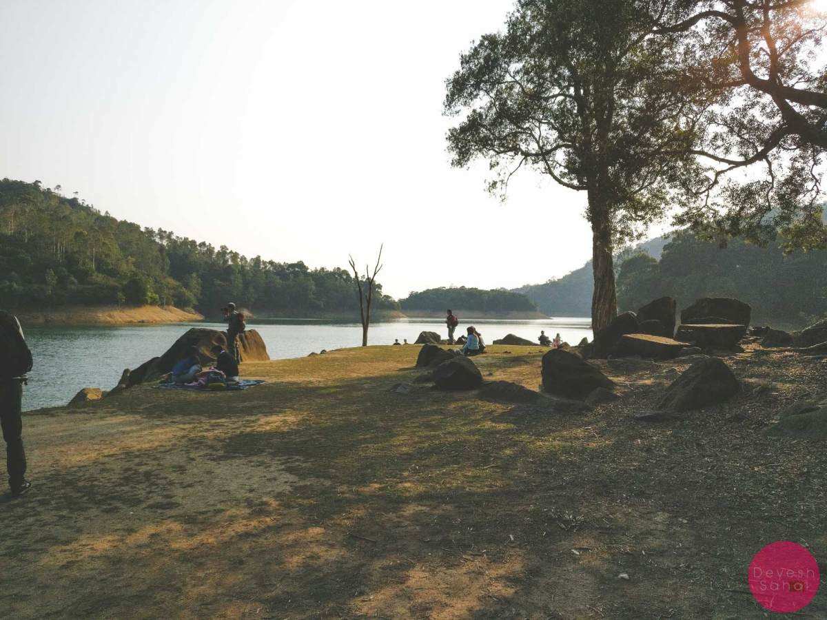 people having a picnic during sunset next to reservoir