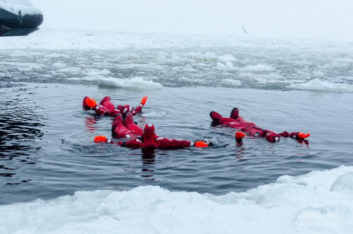 people floating in the middle of the frozen sea